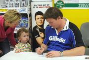 24 September 2009; Conor Byrne, age 2 and a half, from Ballinteer, accompanied by his godmother Martina Leavy, has an autograph signed at a Gillette / Tesco In-Store Signing by Brian O'Driscoll, as fans get a close shave with grand slam hero: Gillette Ambassador Brian O’Driscoll takes part in a Tesco in-store signing much to the delight of the large crowd that packed the Dundrum Town Centre store. The in-store signing is part of a Gillette / Tesco promotion which is offering up to 50% off selected Gillette items including the new Gillette Gamer Razor. The rugby legend will now turn his attention to the new rugby season where he attempts to defend the RBS 6 Nations with Ireland and the Heineken Cup European title with Leinster. Gillette / Tesco In-Store Signing with Brian O'Driscoll, Tesco, Dundrum, Co. Dublin. Picture credit: Brendan Moran / SPORTSFILE  *** Local Caption ***