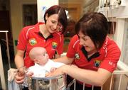 28 September 2009; Jack Mulvihil,l from Dublin, sitting in the Brendan Martin Cup with players and sisters Norita Kelly, left, and Mairead Kelly, during a visit by the winning All-Ireland Cork Ladies Football team to Our Lady's Hospital for Sick Chidren in Crumlin. Crumlin, Co. Dublin. Photo by Sportsfile