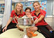 28 September 2009; Emma Chalkley, from Portmarnock, Co. Dublin, with the Brendan Martin cup and captain Mary O'Connor and player Carmel McCarthy, right, during a visit by the winning All-Ireland Cork Ladies Football team to Our Lady's Hospital for Sick Chidren in Crumlin. Crumlin, Co. Dublin. Photo by Sportsfile