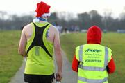 12 December 2009; A general view of a competitor and an Aware volunteer, at the finish of the Aware 10K Christmas Fun Run 2009. The Phoenix Park, Dublin. Picture credit: Tomas Greally / SPORTSFILE