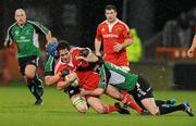 26 December 2009; Tom Gleeson, Munster, is tackled by Keith Matthews, right, and Mike McComish, Connacht. Celtic League, Munster v Connacht, Thomond Park, Limerick. Picture credit: Diarmuid Greene / SPORTSFILE