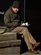 28 February 2016; A punter studies his race card. Leopardstown, Co. Dublin. Picture credit: Cody Glenn / SPORTSFILE