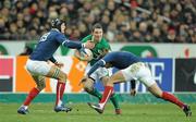 13 February 2010; Paddy Wallace, Ireland, is tackled by Julien Pierre, left, and Francois Trinh-Duc, France. RBS Six Nations Rugby Championship, France v Ireland, Stade de France, Saint Denis, Paris, France. Picture credit: Brendan Moran / SPORTSFILE