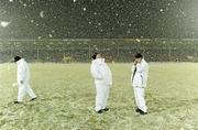 20 February 2010; Umpires Noel Nugent, right, and Seamus O'Brien, centre, wait on the pitch amid falling snow before the game was called off. Allianz GAA Hurling National League, Division 1 Round 1, Tipperary v Kilkenny, Semple Stadium, Thurles, Co. Tipperary. Picture credit: Brendan Moran / SPORTSFILE