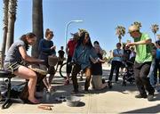 16 March 2016; Ciamh Dollard, left, Laois, and Sinead Finnegan, Dublin, take over the bongo drums from a couple of street performers near the beach during a tour of the city of San Diego. TG4 Ladies Football All-Star Tour. San Diego, California, USA. Picture credit: Brendan Moran / SPORTSFILE