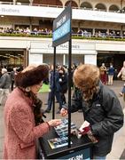 18 March 2016; Maureen Mullins, mother of trainer Willie Mullins, buys her race card from Chantall Herbert ahead of day 4 at the races. Prestbury Park, Cheltenham, Gloucestershire, England. Picture credit: Cody Glenn / SPORTSFILE