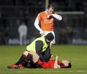 20 March 2010; Martin Clarke, Down, receives treatment from the team doctor as Ciaran McKeever, Armagh, watches. Allianz GAA National Football League, Down v Armagh, Division 2, Round 5, Pairc Esler, Newry, Co. Down. Picture credit: Oliver McVeigh / SPORTSFILE