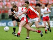 20 May 2001; Cormac McAnallen of Tyrone in action against Paul McGrane of Armagh during the Bank of Ireland Ulster Senior Football Championship Quarter-Final match between Tyrone and Armagh at St Tiernach's Park in Clones, Monaghan. Photo by David Maher/Sportsfile