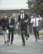 6 April 2016; Students make their way into the racecourse during a heavy shower. Leopardstown, Co. Dublin. Photo by Sportsfile