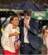 29 April 2016; A couple take shelter under an umbrella as a brief snow shower falls close to the end of racing at the Punchestown Festival. Punchestown, Co. Kildare. Picture credit: Seb Daly / SPORTSFILE