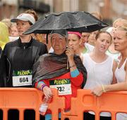 7 June 2010; Ann Doyle, from Rathnew, Co. Wicklow, shelters from the rain before the start of the 2010 Dublin Womens Mini Marathon. 2010 Dublin Womens Mini Marathon, Dublin City. Picture credit: Barry Cregg / SPORTSFILE