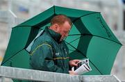 30 June 2010; An Offaly supporter shelters from the rain while reading his programme. ESB Leinster GAA Football Minor Championship Semi-Final, Offaly v Laois, O'Connor Park, Tullamore, Co. Offaly. Picture credit: Brian Lawless / SPORTSFILE