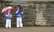 18 July 2010; Sisters Emily, left, age 3, and Holly Butler, age 5, from Clones, Co. Monaghan, shelter from the rain on their way to the Ulster Final. Supporters at the Ulster GAA Football Championship Finals, St Tighearnach's Park, Clones, Co. Monaghan. Picture credit: Brendan Moran / SPORTSFILE