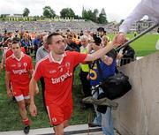 18 July 2010; Ryan McMenamin, Tyrone, is congratulated by a fan as he leaves the pitch. Ulster GAA Football Senior Championship Final, Monaghan v Tyrone, St Tighearnach's Park, Clones, Co. Monaghan. Picture credit: Oliver McVeigh / SPORTSFILE