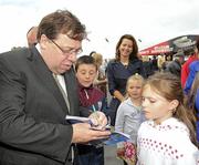 27 July 2010; Nine year old Ellen Conneally, from Athenry, Co. Galway, has her race card autographed by An Taoiseach Brian Cowen, T.D., at the races. Galway Racing Festival 2010, Ballybrit, Galway. Picture credit: Ray McManus / SPORTSFILE