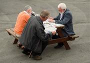 29 July 2010; Three punters try and pick a winner before racing. Galway Racing Festival 2010, Ballybrit, Galway. Picture credit: Ray McManus / SPORTSFILE