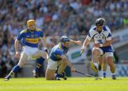 15 August 2010; Eoin Kelly, supported by his Tipperary team-mate Lar Corbett, tries to pull the sliothar from under the feet of Waterford's Noel Connors. GAA Hurling All-Ireland Senior Championship Semi-Final, Waterford v Tipperary, Croke Park, Dublin. Picture credit: Ray McManus / SPORTSFILE