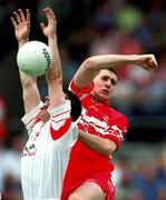 5 August 2001; Colin Holmes of Tyrone contests a dropping ball against Enda Muldoon of Derry during the Bank of Ireland All-Ireland Senior Football Championship Quarter-Final match between Derry v Tyrone at St. Tiernach's Park in Clones, Monaghan. Photo by David Maher/Sportsfile
