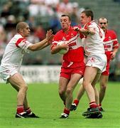 5 August 2001; Dermot Duggan of Derry in action against Kevin Highes, left, and Cormac McAnallen of Tyrone during the Bank of Ireland All-Ireland Senior Football Championship Quarter-Final match between Derry v Tyrone at St. Tiernach's Park in Clones, Monaghan. Photo by David Maher/Sportsfile