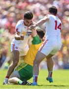 17 July 2016; Martin McElhinney of Donegal is tackled by Tiernan McCann, left, and Sean Cavanagh of Tyrone during the Ulster GAA Football Senior Championship Final match between Donegal and Tyrone at St Tiernach's Park in Clones, Co Monaghan. Photo by Ramsey Cardy/Sportsfile