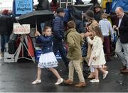 26 July 2016; A family of racegoers walk past the bookmakers in the rain at the Galway Races in Ballybrit, Co Galway. Photo by Cody Glenn/Sportsfile