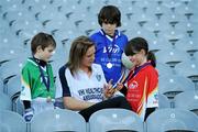 27 September 2010; 300 children from all over the country realised their dreams today when they got to play a match in the world-famous Croke Park stadium as part of the 2010 Vhi Cúl Day Out. The Vhi Cúl Day Out is a nationwide competition which was open to all 80,000 children who attended one of the 1000 Vhi GAA Cúl Camps held over the course of the summer. Today’s lucky 300 winners got to train and play a match in the world-famous stadium. GAA heroes such as Bernard Brogan, Anthony Daly and Eoin Kelly as well as other hurling, football, camogie and handball stars around the country were there to work with the children on the day to help them develop their skills and reinforce their passion for the game. Pictured with Cork footballer Angela Walsh, are, from left, Neil O'Meara, age 7, from Knockbridge, Co. Louth, Darragh Calnan, age 7, from Rosscarbery, Co. Cork and Caoimhe McCabe, age 6, from Bohermeen, Co. Meath. Vhi GAA Cúl Day Out 2010, Croke Park, Dublin. Picture credit: Brendan Moran / SPORTSFILE