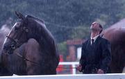 8 August 2001; Peter McDonnell from Portaferry, Co. Down with his two year old fillie The Bught during a rain shower at the Kerrygold Horse Show at the RDS in Dublin. Photo by Matt Browne/Sportsfile