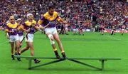 12 August 2001; Wexford captain Darragh Ryan jumps the bench ahead of the taking of the team photograph prior to the Guinness All-Ireland Senior Hurling Championship Semi-Final match between Wexford and Tipperary at Croke Park in Dublin. Photo by Ray McManus/Sportsfile