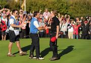 4 October 2010; Hunter Mahan, Team USA, shakes the hand of Graeme McDowell, Team Europe, to conceded the match on the 17th green and give Team Europe the Ryder Cup. The 2010 Ryder Cup, The Celtic Manor Resort, City of Newport, Wales. Picture credit: Matt Browne / SPORTSFILE