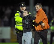 19 October 2010; A supporter is taken away by security staff and a member of the Garda Siochana at the end of the game. FAI Ford Cup Semi-Final Replay, St Patrick's Athletic v Shamrock Rovers, Richmond Park, Inchicore, Dublin. Picture credit: SPORTSFILE