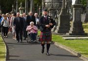 13 August 2016; Nancy Dillon, who was the daughter of James Matthews and her son Charlie follow a lone piper to the grave where a headstone was unveiled on the final resting place of Bloody Sunday victim James Matthews, by Uachtarán Chumann Lúthchleas Aogán Ó Fearghail at a special ceremony in Glasnevin Cemetery. Ray McManus/Sportsfile