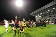 29 October 2010; Team captains Owen Heary, Bohemians, and Liam Burns, Dundalk, lead the teams out for the start of the match. Airtricity League Premier Division, Bohemians v Dundalk, Dalymount Park, Dublin. Picture credit: Brian Lawless / SPORTSFILE