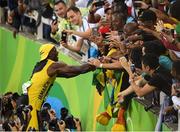 14 August 2016; Usain Bolt of Jamaica celebrates winning the Men's 100m final with fans at the Olympic Stadium during the 2016 Rio Summer Olympic Games in Rio de Janeiro, Brazil. Photo by Ramsey Cardy/Sportsfile