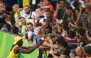14 August 2016; Usain Bolt of Jamaica celebrates winning the Men's 100m final with fans at the Olympic Stadium during the 2016 Rio Summer Olympic Games in Rio de Janeiro, Brazil. Photo by Ramsey Cardy/Sportsfile
