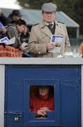 3 February 2010; A coursing fan watches on over a ticket booth for the stand during the meet. 85th National Coursing Meeting - Wednesday, Powerstown Park, Clonmel, Co. Tipperary. Picture credit: Brian Lawless / SPORTSFILE