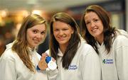 29 November 2010; Ireland's Grainne Murphy, from New Ross, Co. Wexford, with her team-mates Aisling Cooney, left, and Melanie Nocher, on their arrival at Dublin Airport, with her two bronze medals from the European Short Course Swimming Championships in the Netherlands. Dublin Airport, Dublin. Picture credit: Brendan Moran / SPORTSFILE