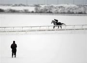 3 December 2010; A general view of a trainer looking on at his horse and jockey as they make their way across the sand Gallop, in freezing conditions, at the Curragh Racecourse, Co. Kildare. Picture credit: Barry Cregg / SPORTSFILE
