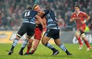 4 December 2010; Mick O'Driscoll, Munster, is tackled by Xavier Rush, left, and Tau Filise, Cardiff Blues. Celtic League, Munster v Cardiff Blues, Thomond Park, Limerick. Picture credit: Brendan Moran / SPORTSFILE