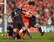 12 December 2010; Tony Buckley, Munster, is tackled by Paul James, left, and Marty Holah, Ospreys. Heineken Cup Pool 3 - Round 3, Munster v Ospreys, Thomond Park, Limerick. Picture credit: Diarmuid Greene / SPORTSFILE