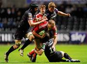 18 December 2010; Mick O'Driscoll, Munster, is tackled by Ospreys players, from left, Jonathan Thomas, Andrew Bishop and James Hook, 12. Heineken Cup, Pool 3, Round 4, Ospreys v Munster, Liberty Stadium, Swansea, Wales. Picture credit: Stephen McCarthy / SPORTSFILE