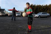 9 January 2011; 10 year old Patrick Caulfield, Ballyhaunis GAA club, takes a break from practicing his skills with his father Tom Caulfield, while Tom directs cars to their parking spaces. The match was postponed after referee TJ Keavney deemed the pitch unplayable. FBD Connacht League, Mayo v Leitrim, Sean O'Heslin Park, Ballyhaunis GAA Club, Ballyhaunis, Co Mayo. Picture credit: Brian Lawless / SPORTSFILE
