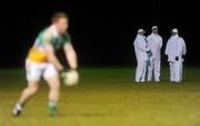 12 January 2011; The umpires wait for the floodlights, at one end of the pitch to be switched on, as the Offaly players warm up on the already lit end. O'Byrne Cup, Offaly v DCU, Rhode, Co. Offaly. Picture credit: Brian Lawless / SPORTSFILE