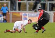 6 February 2011; Sean Cavanagh, Tyrone, lies on the pitch with an injury before being tended to by team physio Michael Harte. Allianz Football League Division 2 Round 1, Derry v Tyrone, Celtic Park, Derry. Picture credit: Oliver McVeigh  / SPORTSFILE