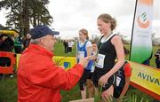 16 February 2011; Carla Sweeney, St MacDara’s CC, is presented with her second place medal by Fr. Ailibe O'Murchu OFM, President of the Leinster Schools' Athletics Union, following the Minor Girls event at the Aviva Leinster Schools Cross Country. Santry Demesne, Santry, Dublin. Picture credit: Stephen McCarthy / SPORTSFILE