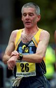 29 October 2001; Ireland's first finished John Griffin checks his time as he crosses the line during the adidas Dublin Marathon 2001, finishing in a time of 02:23:21. Photo by Ray McManus/Sportsfile