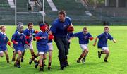 31 October 2001; The Irish Rugby Football Union and Kellogg's Frosties have teamed up to launch Frosties Youth Development Programme, a new and exciting partnership aimed at introducing new recruits to the game. The project imbraces the involvement of 76 employed Youth Development Officers liasing with a potential 430 schools around Ireland in a 26 week programme, from Sept to Easter, with the aim of introducing to the game of rugby, schoolchildren from the age group of under 8's to 15 years. Pictured at the launch are Leinster and Ireland second row Malcolm O'Kelly tackled by schoolchildren from Dublin. Photo by Brendan Moran/Sportsfile