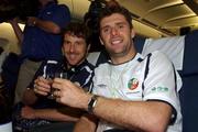 16 November 2001; Republic of Ireland players Niall Quinn and Kenny Cunningham celebrate with a glass of champagne on board their return flight to Dublin from Tehran, Iran, after the Republic of Ireland soccer team qualified for the 2002 World Cup Finals in Japan. Photo by David Maher/Sportsfile