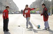 27 March 2011; Zinddine Medahdeh, age 7, left, Craig Conyard, age 10, and Scott Judge, age 8, from Piorswood School Boys and Girls Football Club, Coolock, Dublin, pass the time ahead of the Dublin leg of the John Giles Foundation, 'Walk of Dreams', in association with Three, Ireland's fastest growing mobile network. The fundraising walk which took place in 14 locations nationwide brought nearly 50,000 people from all over Ireland to raise funds for the beautiful game and the John Giles Foundation, to continue the growth of football. The ‘Walk of Dreams’ took place in Letterkenny, Sligo, Castlebar, Galway City, Ennis, Limerick City, Tralee, Cork City, Athlone, Thurles, Waterford City, Enniscorthy, Dublin City and Dundalk. The John Giles Foundation was founded to use football as a vehicle for social change, to build community cohesion, increase participation and to improve health and education by providing funding to help football in clubs, schools and community groups in Ireland. Half of the funds raised will be retained by participating football clubs while the other half will go to the Foundation for community football projects in clubs, schools and community groups throughout Ireland. John Giles Foundation ‘Walk of Dreams’ in association with Three. Fitzwilliam Street via Ringsend to Aviva Stadium. Picture credit: Stephen McCarthy / SPORTSFILE