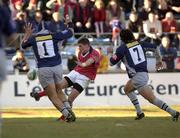 12 January 2002; Ronan O'Gara of Munster kicks for touch despite the attentions of Mauricio Reggiardo, left, and Romain Froment of Castres during the Heineken Cup Pool 4 Round 6 match between Castres and Munster at Stade Pierre-Antoine in Castres, France. Photo by Brendan Moran/Sportsfile