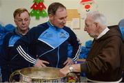 21 December 2016; Dublin football manager Jim Gavin with Br. Kevin Crowley and the Sam Maguire Cup as they lend a hand packing some of the 3,000 Christmas parcels for the homeless at the Capuchin Day Centre on Bow Street, Dublin. Photo by Piaras Ó Mídheach/Sportsfile